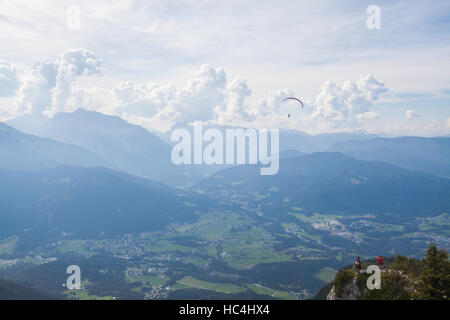 Color image of a paraglider flying, with clouds in the background. Stock Photo