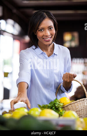 Smiling woman buying fruits in organic section Stock Photo