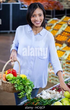 Woman buying vegetables and fruits in organic section Stock Photo