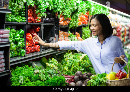 Woman buying vegetables in organic section Stock Photo