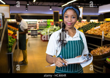Female staff writing on notepad in super market Stock Photo