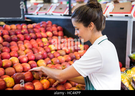 Female staff arranging fruits in organic section Stock Photo