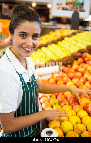 Female staff arranging fruits in organic section of supermarket Stock Photo