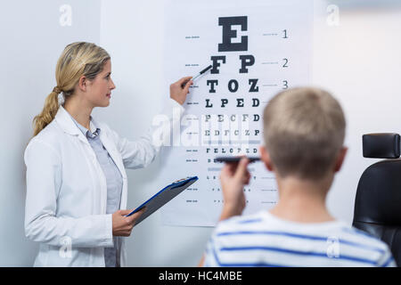 Female optometrist taking eye test of young patient Stock Photo