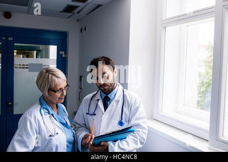 Doctors discussing over clipboard Stock Photo