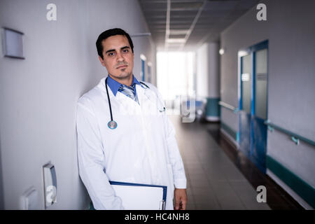 Sad doctor leaning against the wall Stock Photo