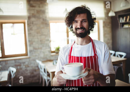 Male baker holding a cup of coffee Stock Photo