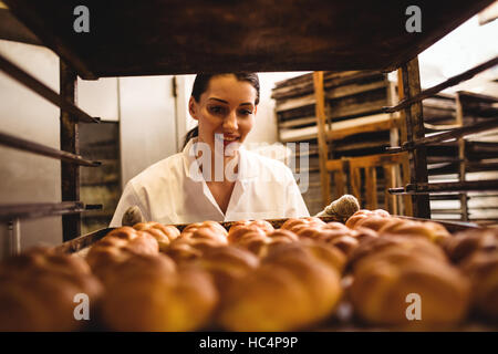 Female baker holding a tray of michetta Stock Photo