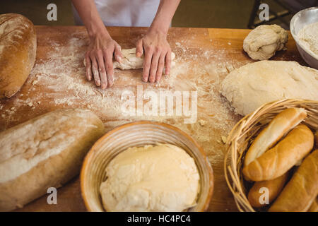 Hands of female baker kneading a dough Stock Photo