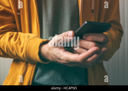 Unlocking smartphone with fingerprint scan sensor, man using modern security technology feature to authenticate access and use device Stock Photo