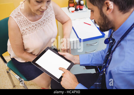Doctor discussing with patient over digital tablet Stock Photo
