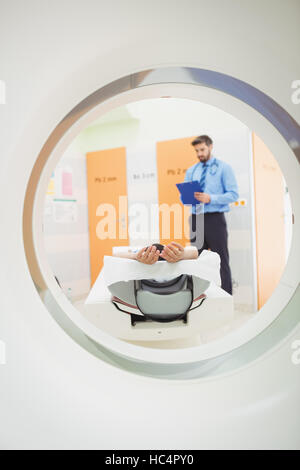 Doctor reviewing chart of patient about to have mri scan Stock Photo