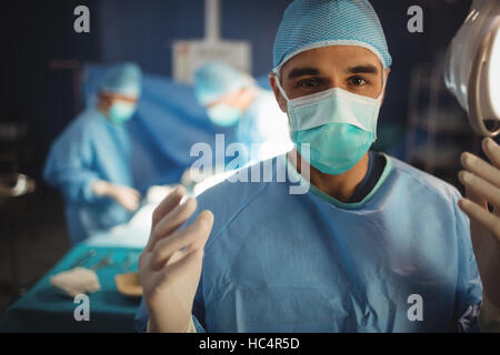 Portrait of male surgeon preparing for operation in operation room Stock Photo