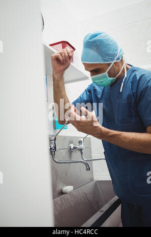 Male surgeon washing hands prior to operation using correct technique for cleanliness Stock Photo