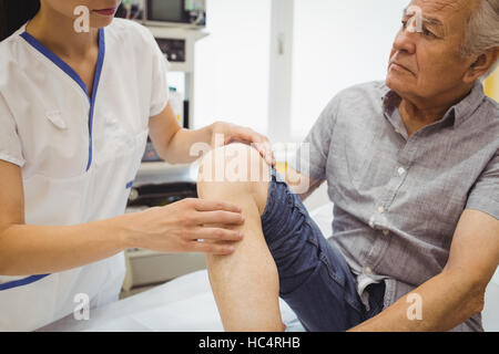 Female doctor examining patients knee Stock Photo
