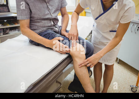 Female doctor examining patients knee Stock Photo