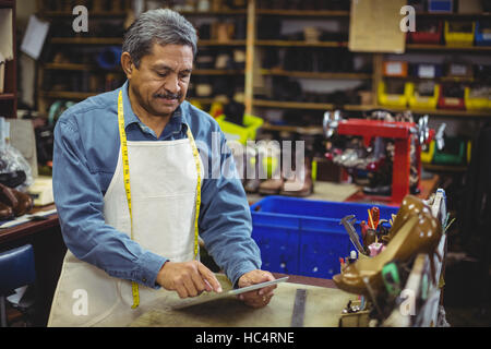 Shoemaker using digital tablet Stock Photo