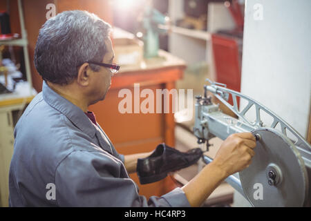 Shoemaker using sewing machine Stock Photo