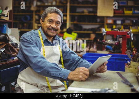 Portrait of shoemaker using digital tablet Stock Photo