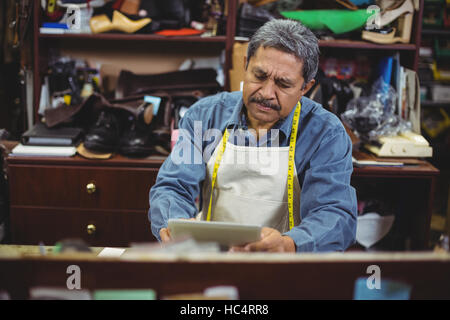 Shoemaker using digital tablet Stock Photo