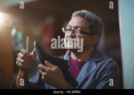 Shoemaker repairing a shoe Stock Photo