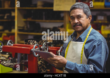 Shoemaker using digital tablet Stock Photo