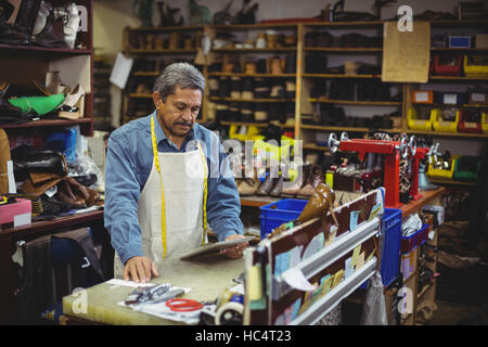 Shoemaker using digital tablet Stock Photo