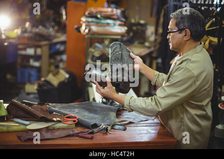 Shoemaker examining a leather boot Stock Photo