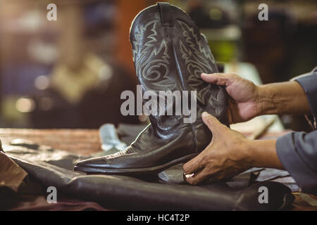 Shoemaker holding a leather boot Stock Photo