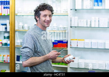 Customer using mobile phone with a bottle of drug in hand Stock Photo