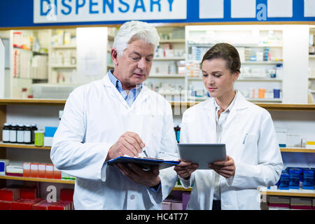 Pharmacists discussing on digital tablet and clipboard Stock Photo