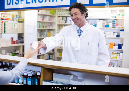 Pharmacist giving pill bottle to customer Stock Photo