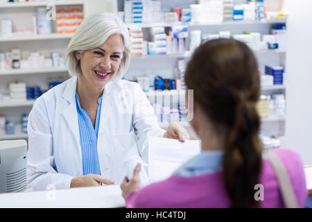 Pharmacist giving prescriptions of medicine to customer Stock Photo