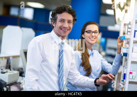 Pharmacists checking medicines on shelf in pharmacy Stock Photo
