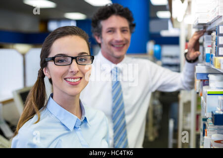 Pharmacists checking medicines on shelf in pharmacy Stock Photo