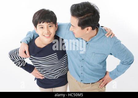 High angle view of smiling middle aged father and adolescent son putting hands on each other's shoulders Stock Photo