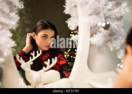 girl sitting near mirror and deer at  new year and comb hair Stock Photo