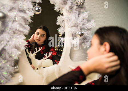 girl sitting near mirror and dear at  new year and comb hair Stock Photo