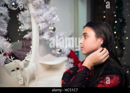 girl sitting near mirror and dear at  new year and comb hair Stock Photo