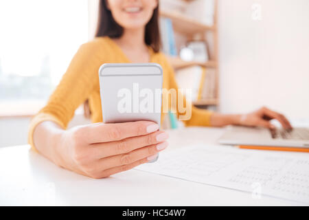 Cropped image of a casual woman using smartphone in office Stock Photo