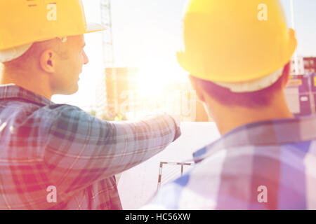 close up of builders with blueprint at building Stock Photo