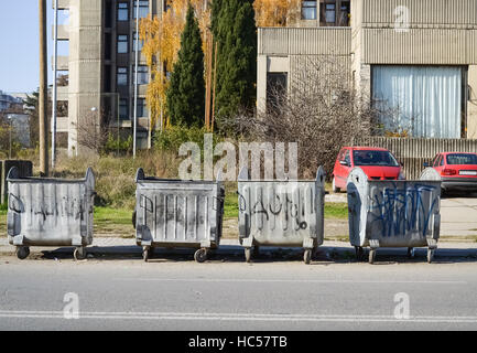 Several metal dumpsters on the street in an urban settlement Stock Photo