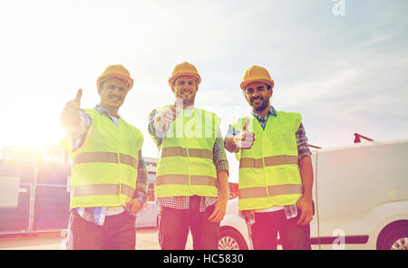 happy male builders in high visible vests outdoors Stock Photo