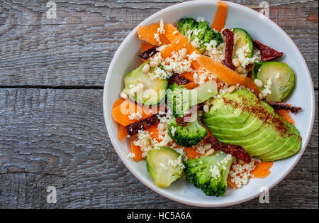 Couscous with broccoli, avocados, carrots, Brussels sprouts, dried tomatoes and pine nuts. . Perfect for the detox diet or just a healthy meal.  Love Stock Photo