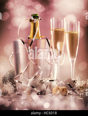 Two glasses of champagne with bottle in cooler on a pink background, selective focus Stock Photo