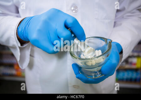 Pharmacist grinding medicine with mortar and pestle Stock Photo