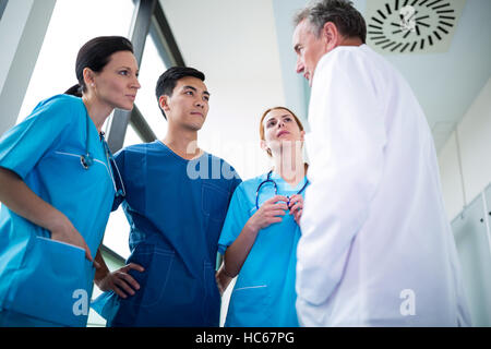 Doctor and surgeons interacting wit each other in corridor Stock Photo