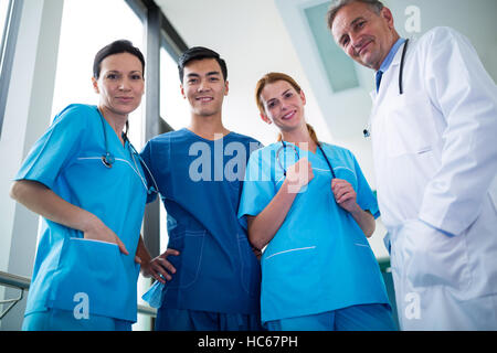 Portrait of doctor and surgeons standing together in corridor Stock Photo