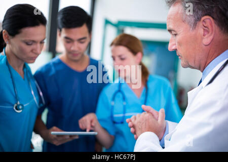 Doctor and surgeons interacting wit each other in corridor Stock Photo