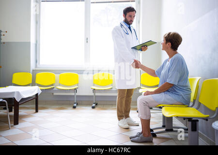 Doctor shaking hand with patient in waiting room Stock Photo